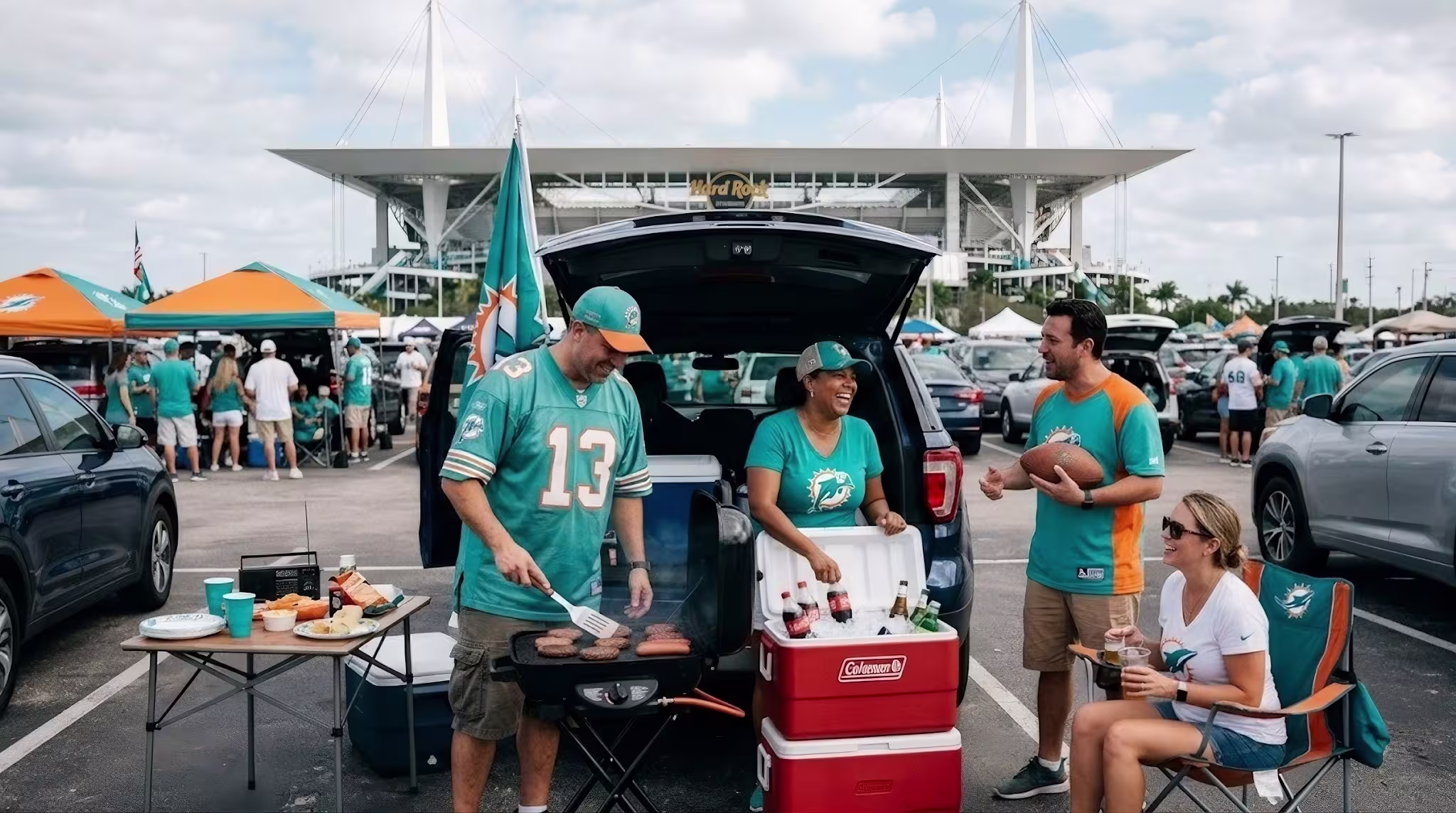 Fans tailgating outside Hard Rock Stadium with grills, chairs, and Miami Dolphins team colours