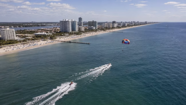 Fort Lauderdale Coast from Above Aerial view of jet skiing and parasailing along Fort Lauderdale's Atlantic coastline on a sunny summer day